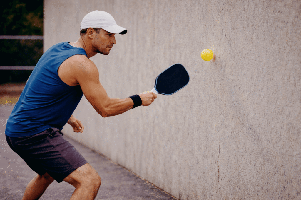 pickleball player practicing speed up shot drills against the wall