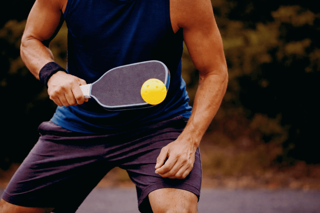 Pickleball player targeting opponent hip with speed up shot at the kitchen line